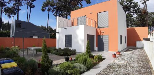 a house with an orange and white facade at Casa da Falésia in Almada