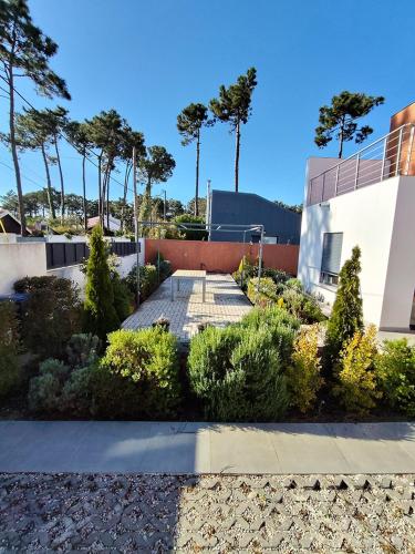 a garden in front of a building with trees at Casa da Falésia in Almada