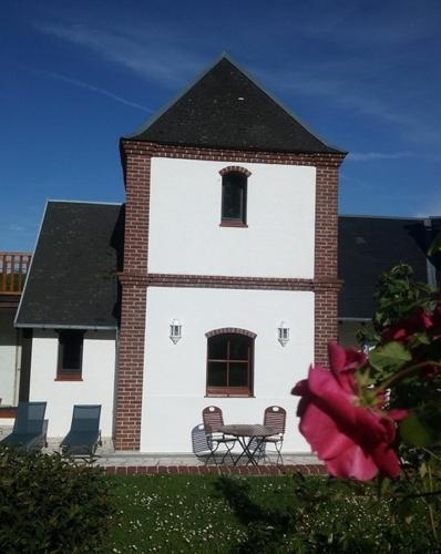 a building with a table and chairs in front of it at le bien l'authie in Colline-Beaumont