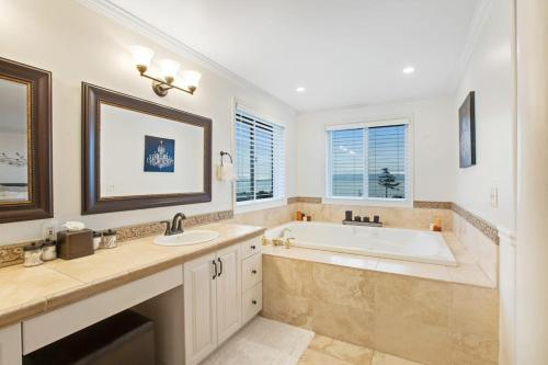 a white bathroom with a tub and a sink at Island Time Escape in Saratoga Shores