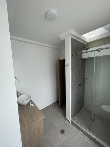 a bathroom with a glass shower and a sink at Hotel Portal Del Cerro Manizales in Manizales