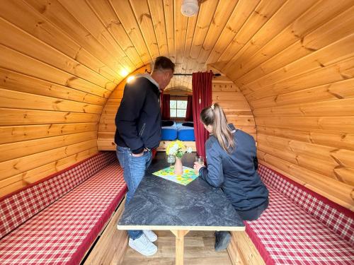 a man and a woman sitting at a table in a room at Campingfass Zur Adria in Großdubrau