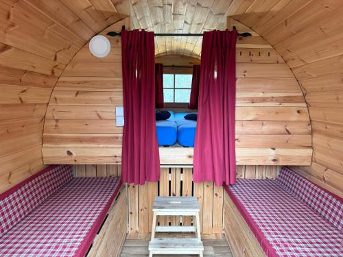 an inside view of a sauna with red curtains at Campingfass Zur Adria in Großdubrau