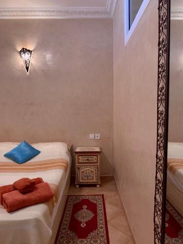 a small room with two beds and a table at Appartement terrasse de la mer in Mirleft