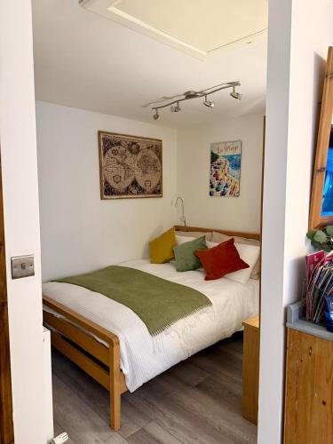 a bedroom with a bed with colorful pillows at St Catherines, Winterborne Lodge in Blandford Forum