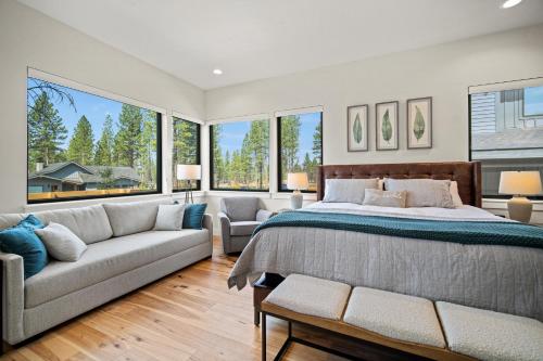 a bedroom with a bed and a couch and windows at 18124-2 Forestbrook Loop in Bend