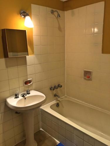 a bathroom with a sink and a bath tub at Hostal Urbano in Tarija