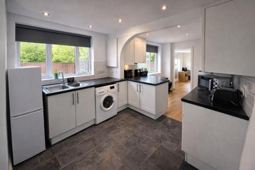 a kitchen with white cabinets and a sink and a dishwasher at Urban in Southampton