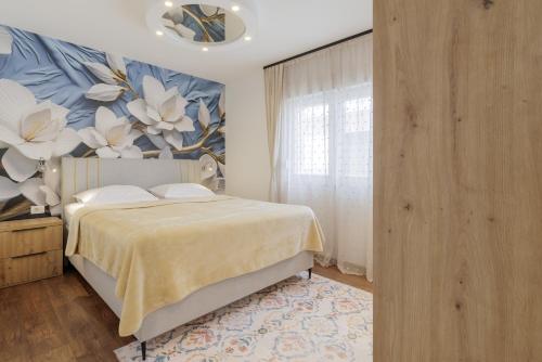 a bedroom with a bed with a floral wall at HoUsE MILETIC in Solin