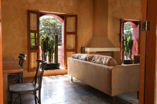 a living room with a couch and two windows at Casa María Guest House in Santa Cruz Etla