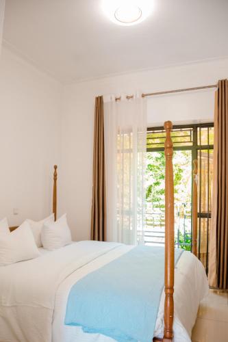 a bedroom with a bed and a window at Migano Hotel in Ruhengeri