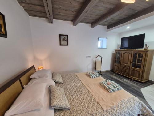 a bedroom with two beds and a flat screen tv at Gerendás in Szilvásvárad