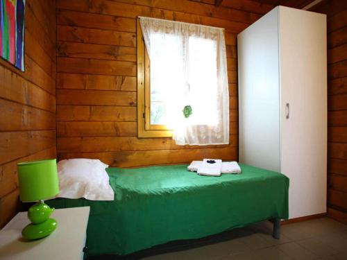 Villaggio La Bussola في باولا: غرفة نوم بسرير اخضر مع نافذة