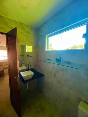 a bathroom with a sink and a window at Casa Brisa do Mar in Cabedelo