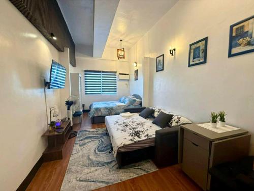 a bedroom with a couch and a bed in a room at Kim's Cozy Place - Parthenon Residences in Cebu City