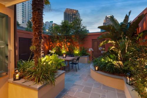 a patio with tables and plants on a building at Historic CBD Townhomes with Courtyard in New Orleans