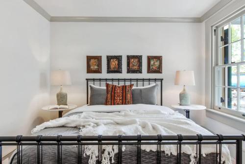 a bedroom with a large bed with white walls and windows at Historic CBD Townhomes with Courtyard in New Orleans
