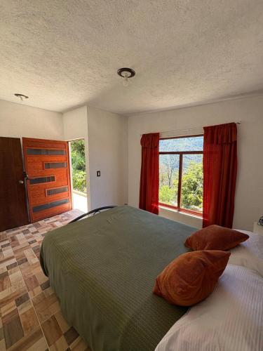 a bedroom with a bed and a large window at Brisa Campestre in Tomatlán