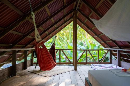 a room with a hammock in a tent at La Aldea del Primitivo in Nuquí
