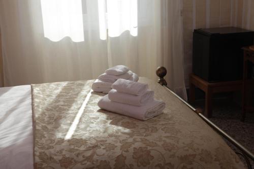 a pile of towels sitting on top of a bed at The Corner Tivoli in Tivoli