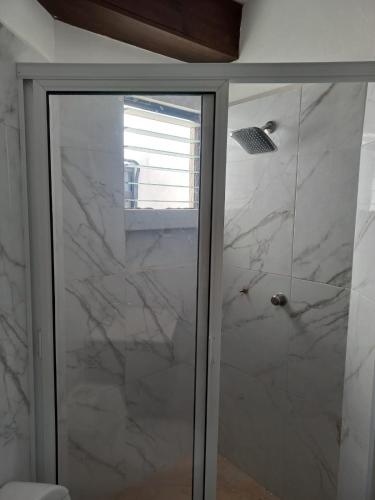 a shower with a glass door in a bathroom at Invernadero Inn in Veracruz