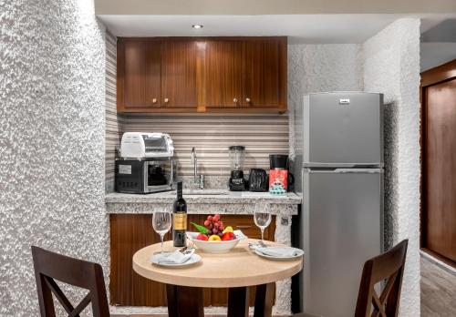 a kitchen with a table with a bowl of fruit and a refrigerator at El Cid El Moro Beach in Mazatlán