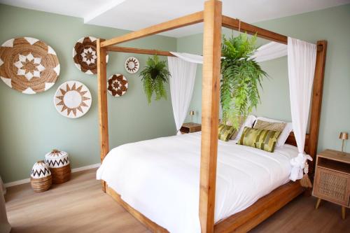 a bedroom with a wooden canopy bed with white sheets at Prime apartment in Liège
