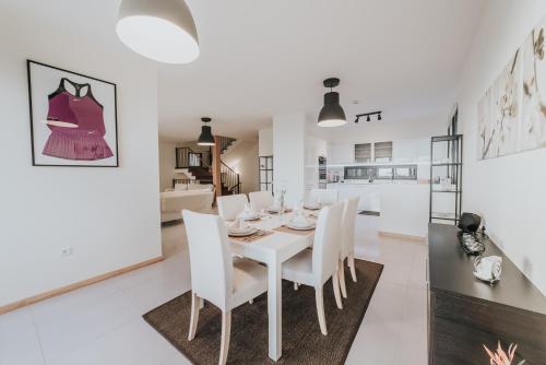 a white dining room with a white table and chairs at Ocean View Villa in Funchal