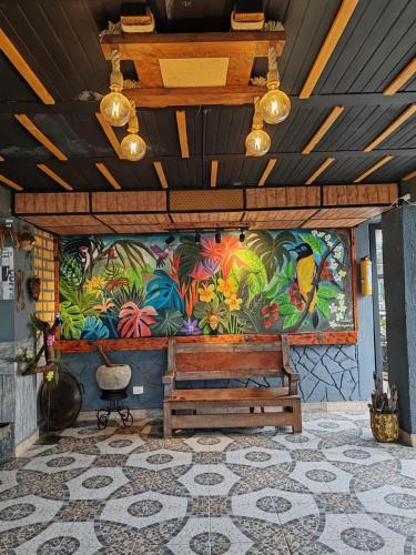 a large painting on the wall of a room with a table at Finca Campestre Villa del Campo in Santa Rosa de Cabal
