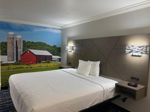 a bedroom with a large bed and a red barn at Travelodge by Wyndham Odessa in Odessa