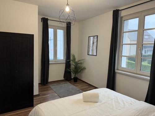 a bedroom with a bed and a large window at 2BR, terrace, free parking in Leverkusen