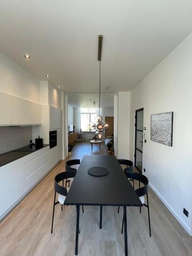 a living room with a table and chairs and a kitchen at Cabine Congé sfeervol appartement dichtbij zee in Ostend