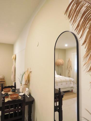 a dressing room with a mirror and a bed at Casa Magu Merida in Mérida