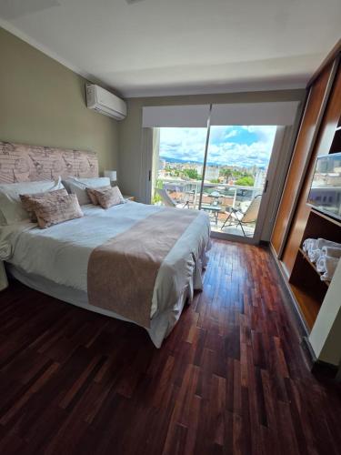 a bedroom with a large bed and a large window at Caseros Desings Salta in Salta