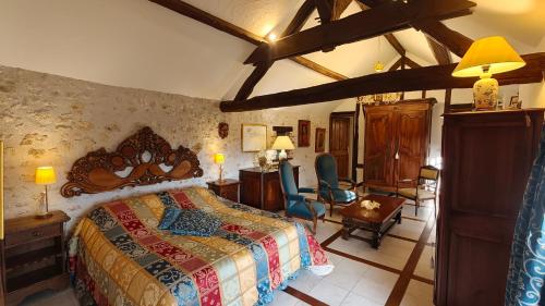 a bedroom with a bed and a desk and chairs at Le Relais de la Tour in La Chaussée-Saint-Victor