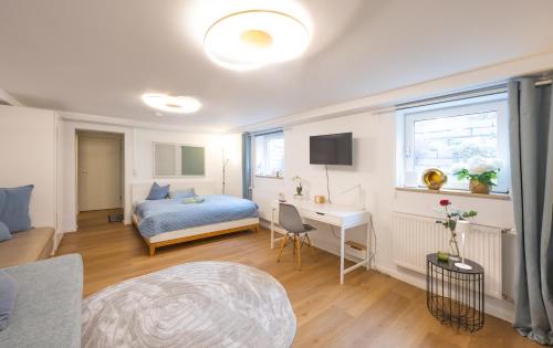 a bedroom with a bed and a desk in a room at Ruhig Top mod Studio Appartement,privater Eingang in Oberhaching