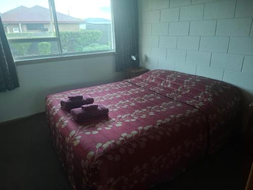 a bedroom with a bed with a red blanket at Aalton Motel Temuka in Temuka