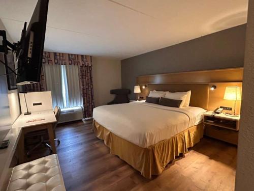 a hotel room with a bed and a television at Urbana Hotel Conference Center in Urbana