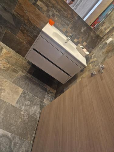 a bathroom with a sink and a wooden floor at Villa janna in Sukrah