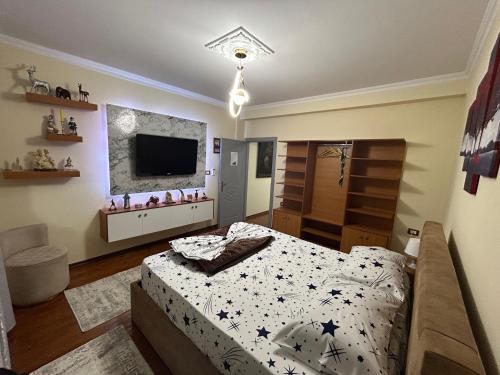 a bedroom with a bed and a flat screen tv at Vila Spaho in Korçë