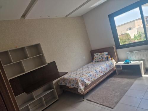 a bedroom with a bed and a window at Villa janna in Sukrah