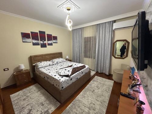 a bedroom with a bed and a tv and a mirror at Vila Spaho in Korçë