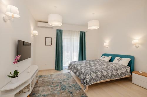 a bedroom with a bed and a desk and a window at River side apartment B3 in Herceg-Novi