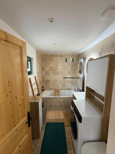 a bathroom with a tub and a sink and a bath tub at Logis cosy avec piscine in Saint-Josse