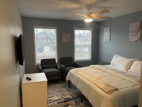 a bedroom with a bed and a chair and a ceiling fan at Stylish 3BR Townhouse in Radcliff