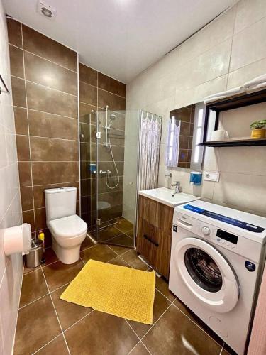 a bathroom with a toilet and a washing machine at Ocean Grace Residence in Batumi