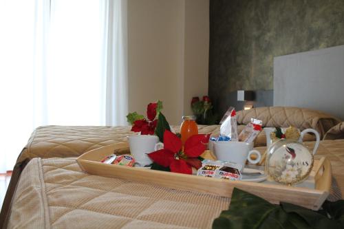 a tray with cups and tea cups on a bed at Halanus Hotel And Resort in Alanno