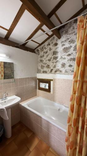 a bathroom with a bath tub and a sink at Maison des Cévennes in Arphy