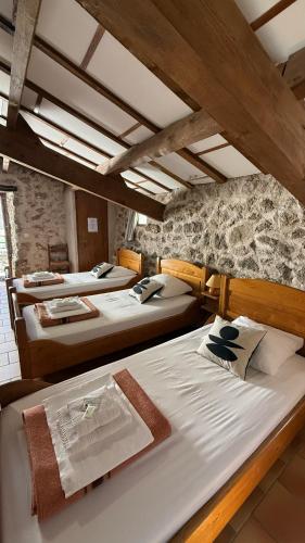 a group of four beds in a room at Maison des Cévennes in Arphy