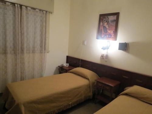 a hotel room with two beds and a window at Hotel Trocadero in Necochea